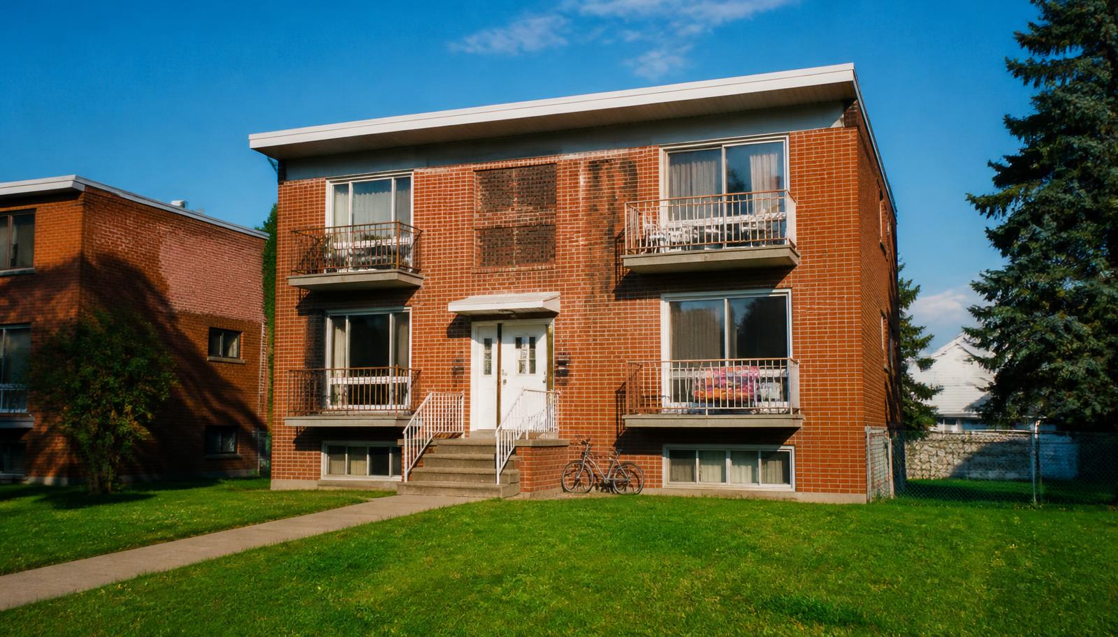 Brick fourplex apartment building with a green lawn